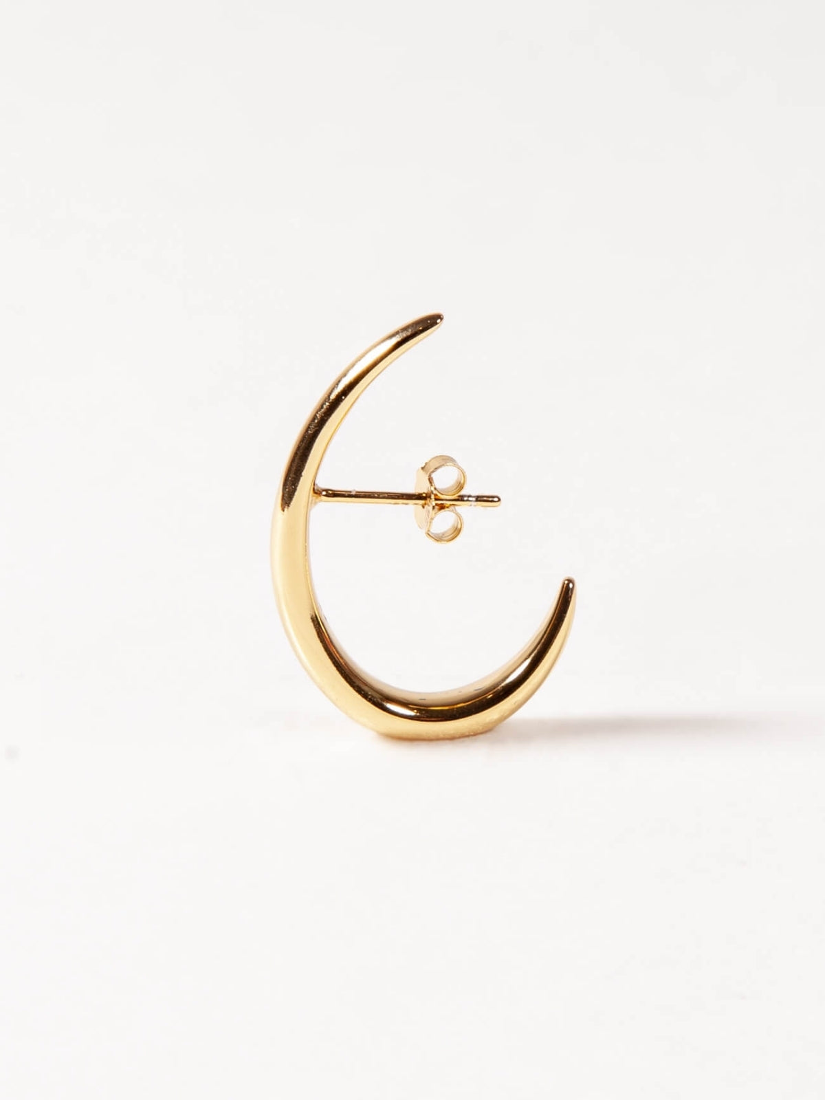 Gold crescent moon earring on a white background