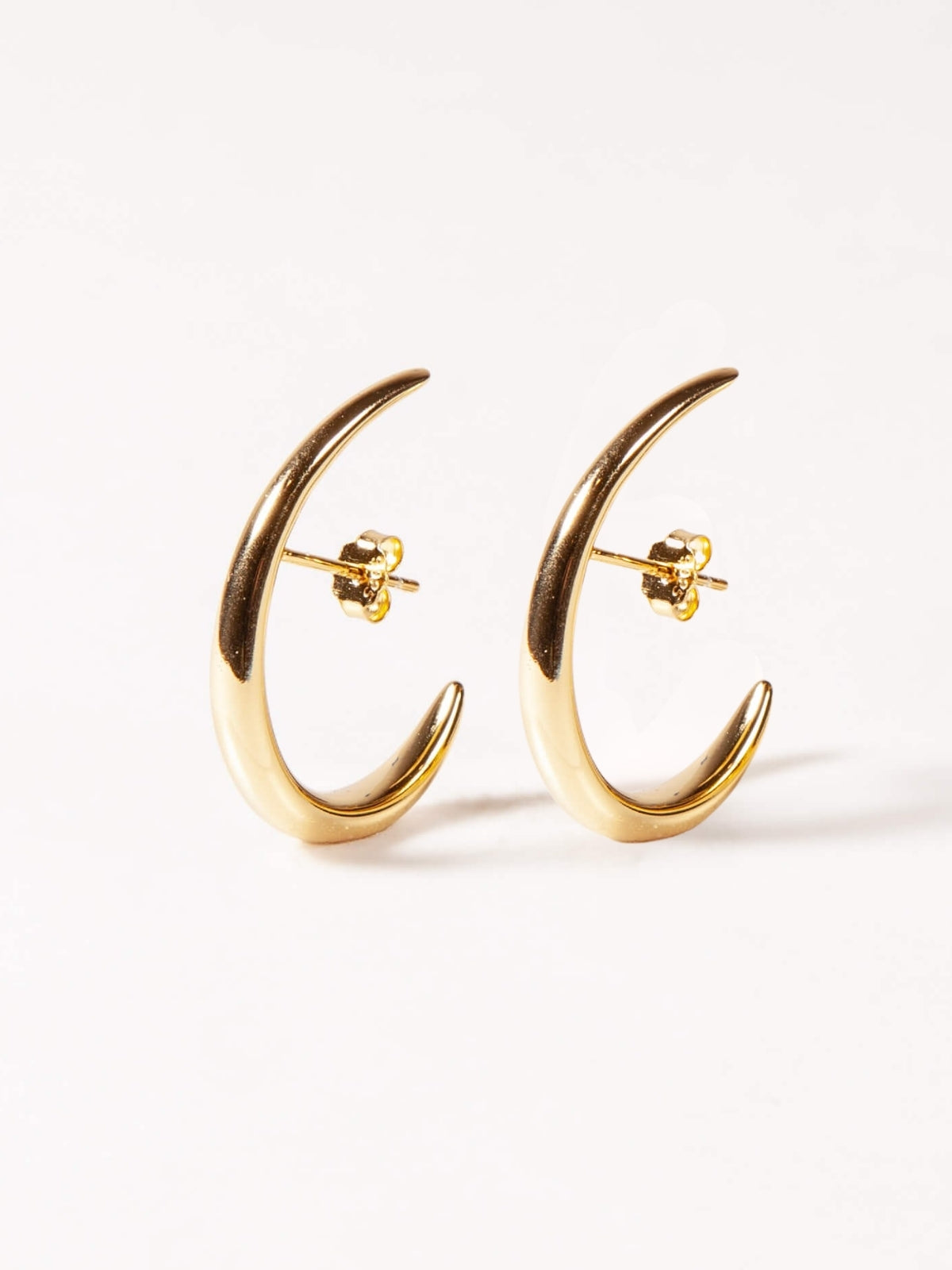Gold crescent moon earrings on a white background