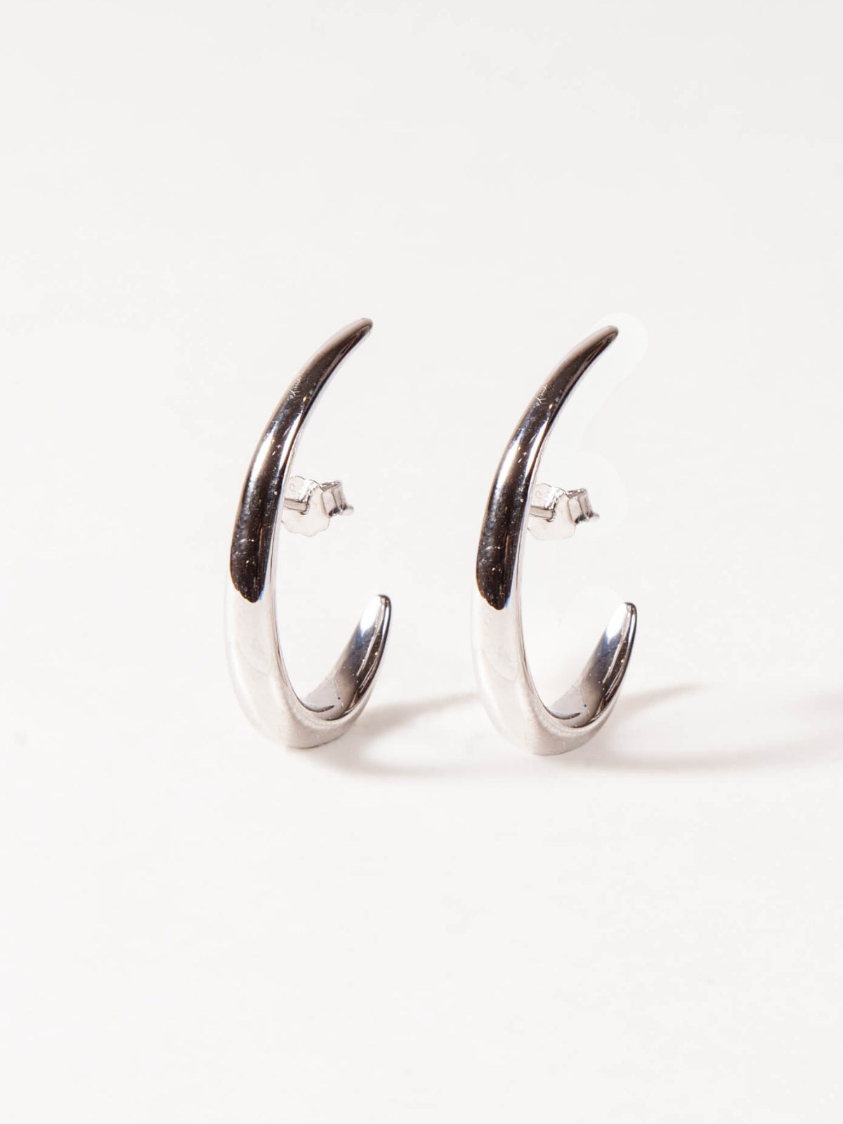 Pair of silver earrings with modern design on a white background