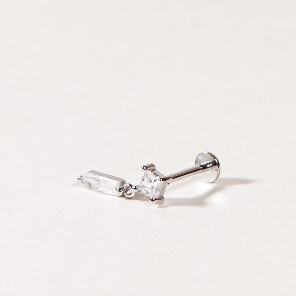 Silver earring with clear gemstones on a light gray background