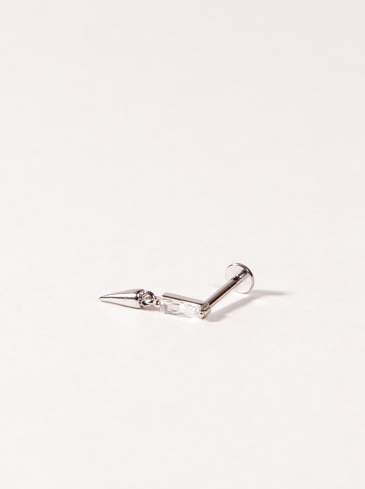 A single flatback stud earring with a silver-colored post and clear cubic zircon
