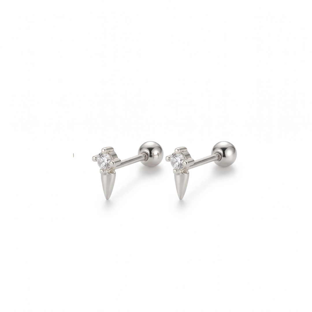A pair of silver stud earrings featuring a small clear cz and a pointed spike detail, shown on a plain white background.